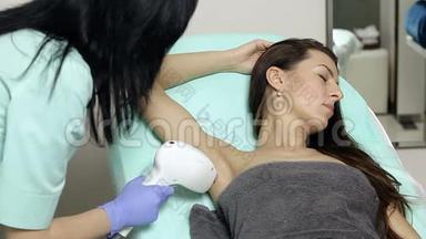美容师对病人腋窝进行激光脱毛。 脱毛程序